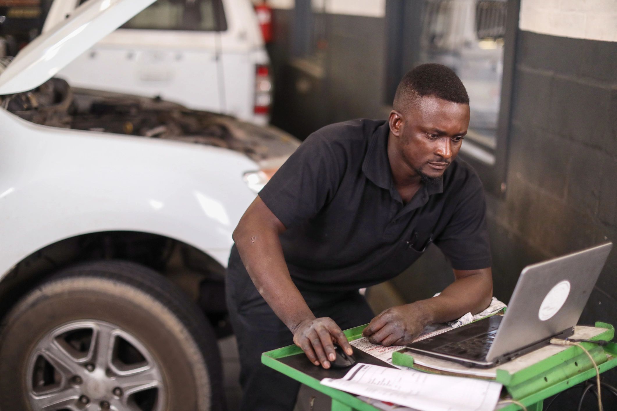 Technician using a laptop while working on an engine
