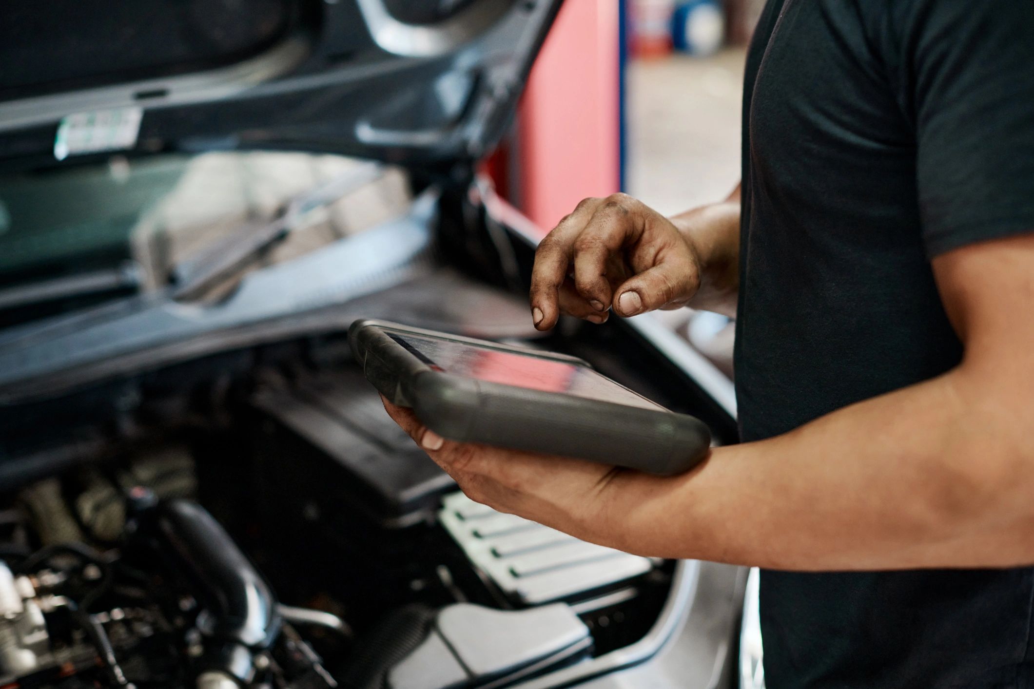 Mechanic using a digital tablet to perform vehicle diagnostics in a repair shop