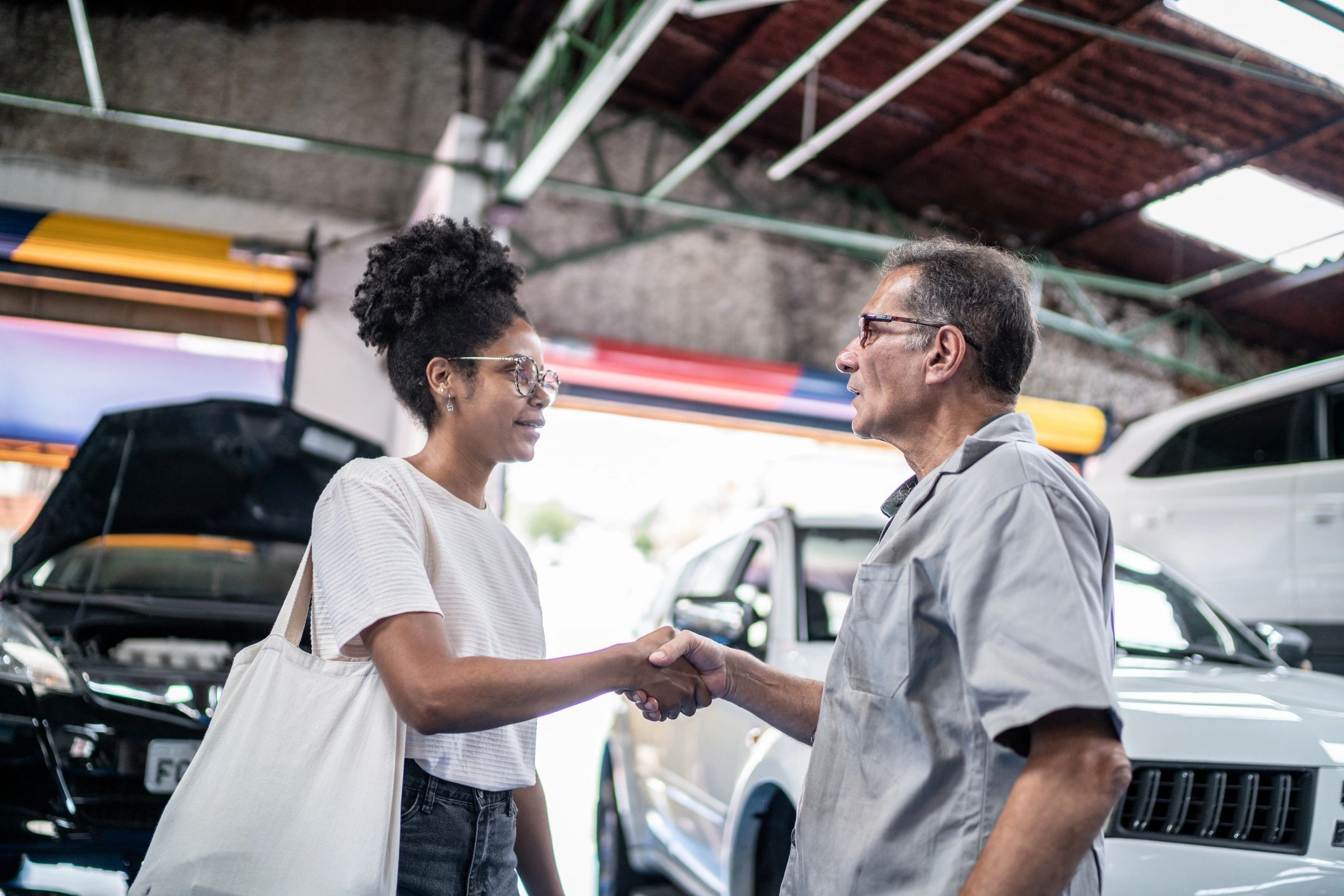 Customer and mechanic shaking hands at a repair shop