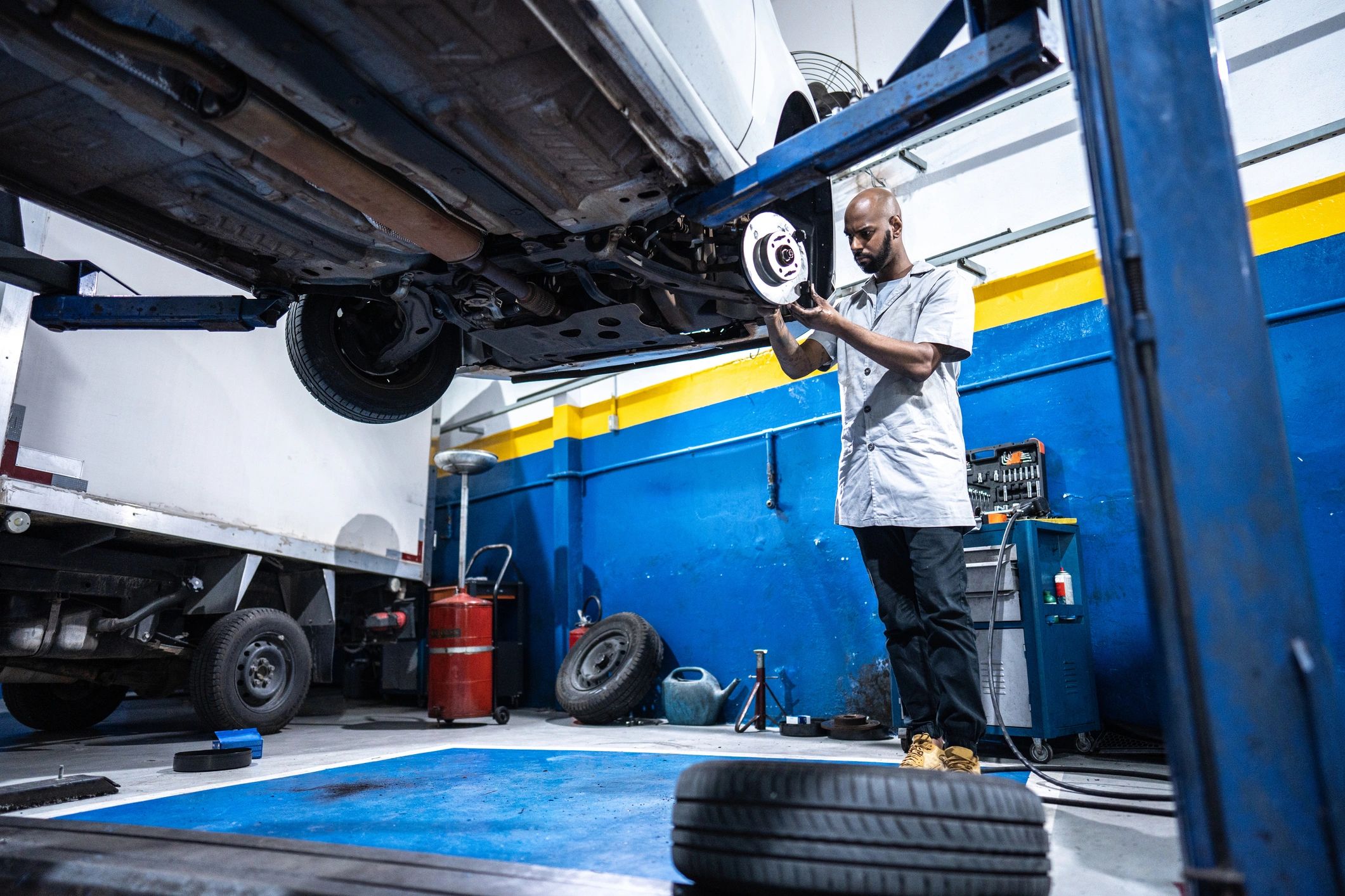 Mechanic working on a vehicle brake assembly in the shop