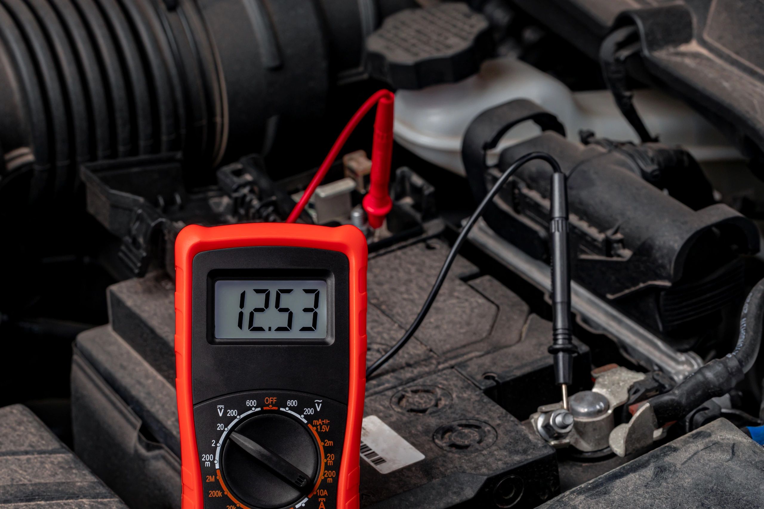 Technician using a battery tester on a vehicle