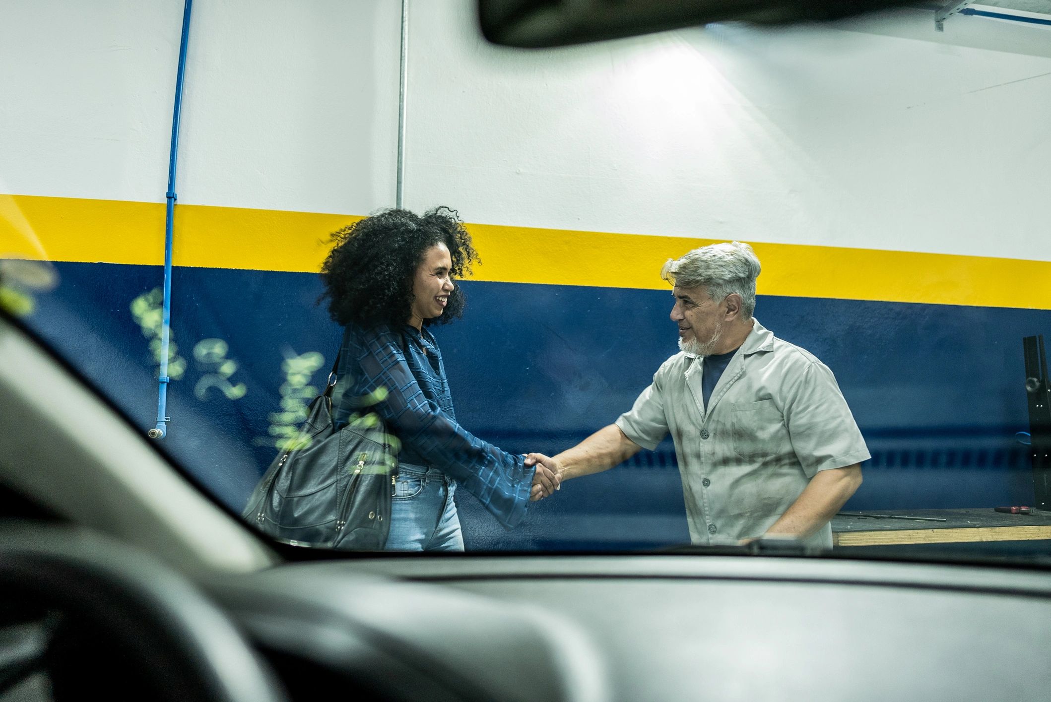 Mechanic greeting a customer at the service counter