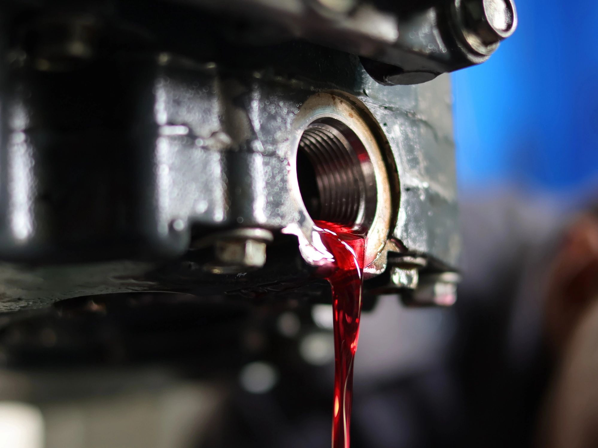 Mechanic loosening an automatic transmission drain plug during service